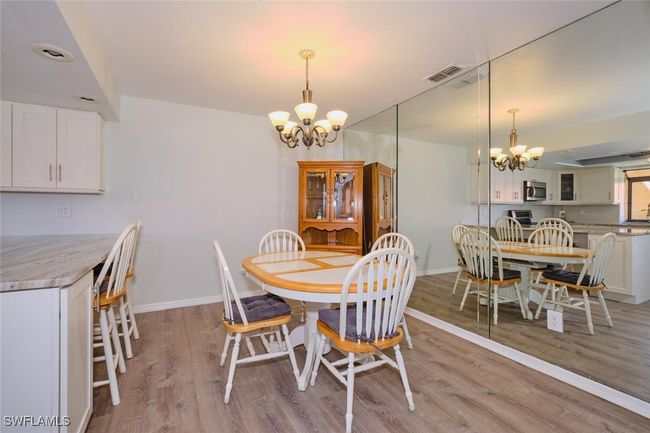 Dining room with a chandelier and light wood finished floors | Image 10