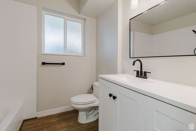 Full bath featuring toilet, baseboards, wood finished floors, and vanity | Image 14