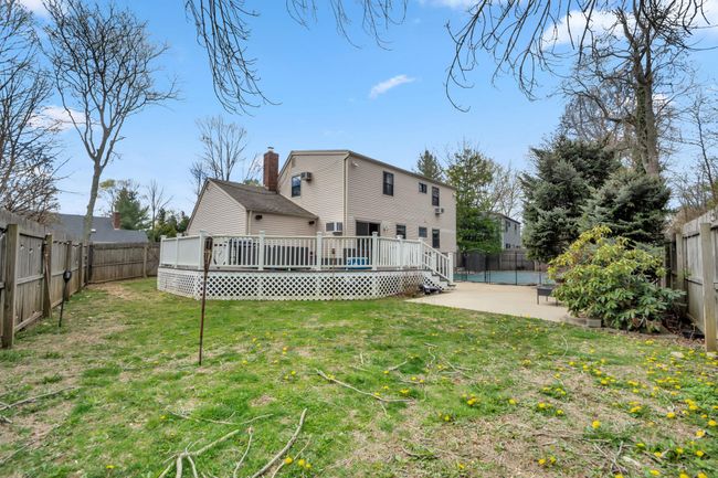 Back of house featuring a deck, a fenced backyard, a chimney, and a patio | Image 11