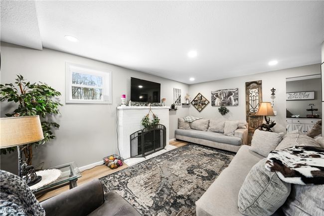 Living area featuring baseboards, recessed lighting, wood finished floors, and a fireplace | Image 9