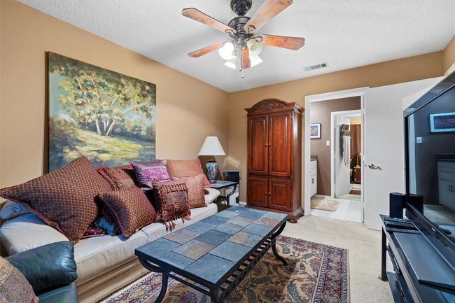Living room featuring a textured ceiling, visible vents, a ceiling fan, and light colored carpet | Image 25