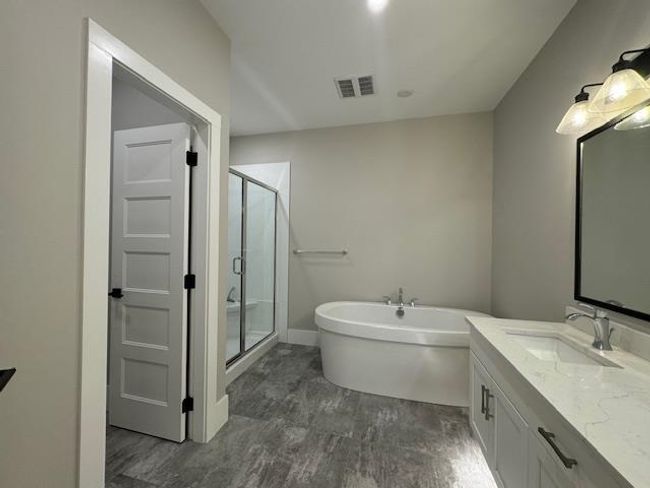 Full bathroom with a freestanding bath, visible vents, wood finished floors, a shower stall, and vanity | Image 26