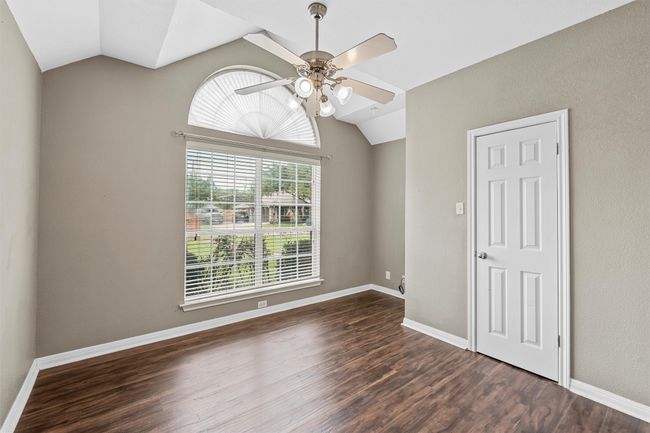 Spare room featuring vaulted ceiling, ceiling fan, and dark wood-style flooring | Image 10
