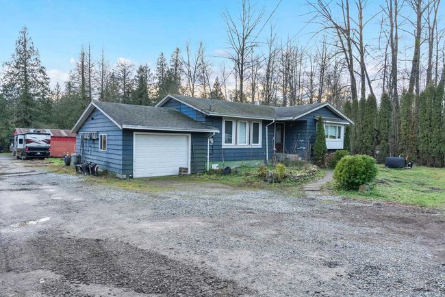 View of front of property with a garage, driveway, and a shingled roof | Image 9