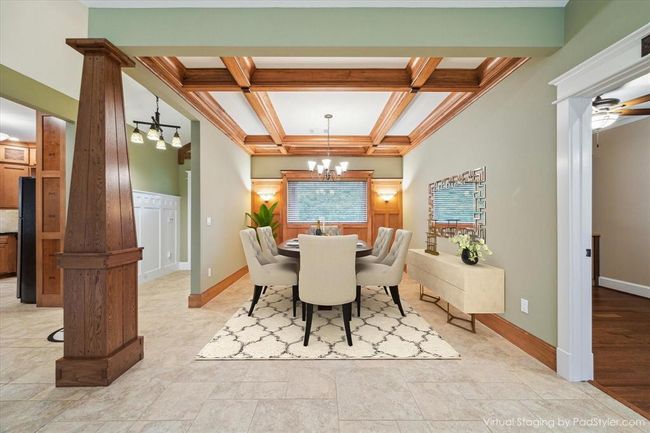 THE DINING AREA IS CROWNED WITH A BEAUTIFULLY CRAFTED COFFERED CEILING, ADDING ARCHITECTURAL ELEGANCE.CUSTOM WOOD TRIM AND PANELED WALL LINE THE ROOM WITH PRECISION AND CUSTOM LANTERNS ADD AMBIENCE TO THE WARM GLOWING DINING ROOM. | Image 8