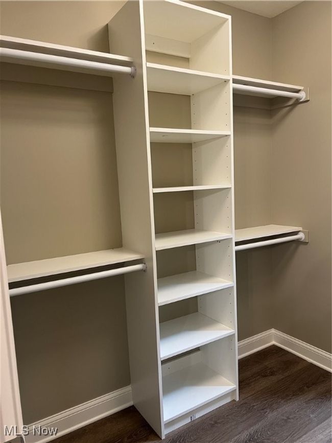 Spacious closet featuring dark wood-type flooring | Image 13