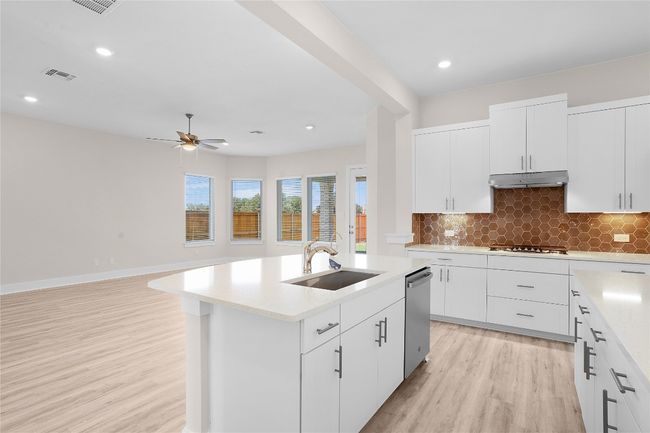Kitchen with a sink, dishwasher, light wood-style floors, light countertops, and recessed lighting | Image 11