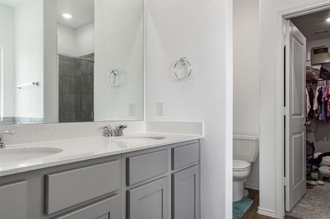Bathroom featuring double vanity, toilet, a shower, and a sink | Image 22