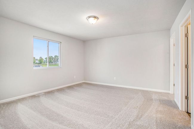 The primary suite includes a private bath and an oversized walk-in closet with a front facing exterior window to optimize natural lighting. | Image 11