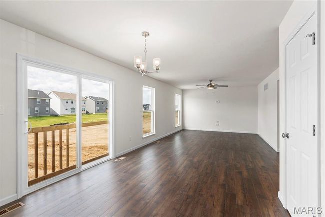 Unfurnished room featuring a chandelier, dark wood-style floors, and a ceiling fan | Image 26