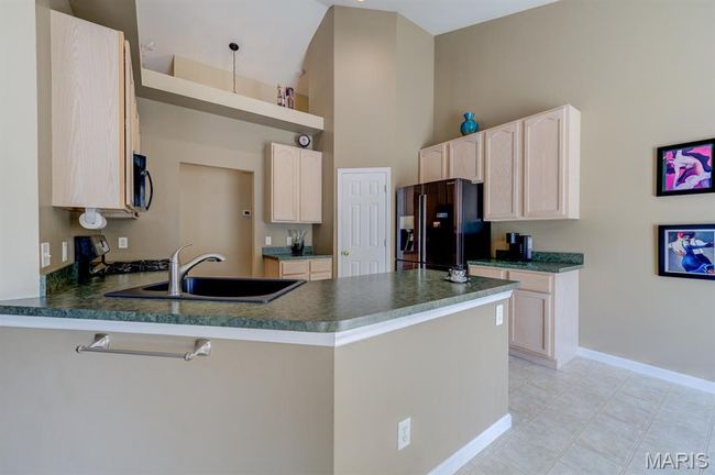 The kitchen has a double sink, disposal, and a peninsula (instead of a freestanding island). | Image 10