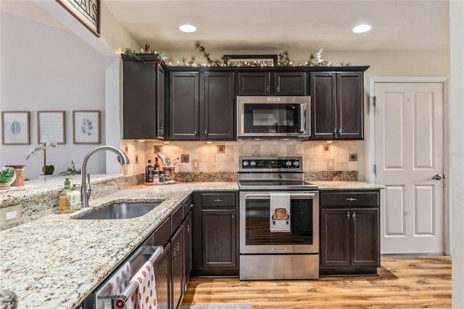 Espresso cabinets, granite counters, upgraded sink and faucet, under and over cabinet lighting and Kitchenaid stainless steel appliances | Image 6