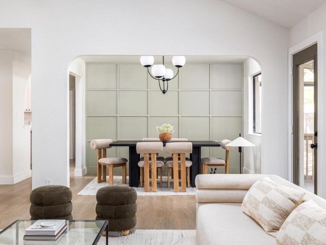 Living area with arched walkways, baseboards, wood finished floors, and vaulted ceiling | Image 12