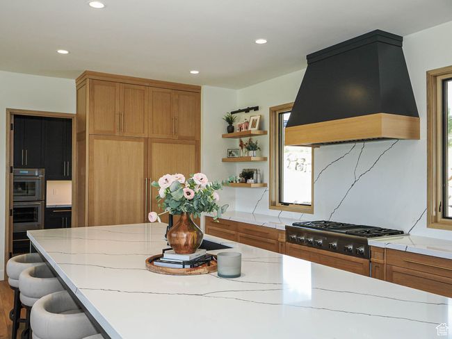 Kitchen featuring open shelves, custom exhaust hood, light countertops, recessed lighting, and appliances with stainless steel finishes | Image 35