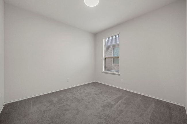 Empty room featuring baseboards and dark carpet | Image 10