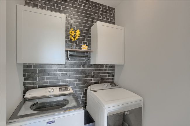 Super cute laundry room with cabinetry and floating shelf anchored on the accent wall creating a fun space to do a not so fun chore! | Image 38
