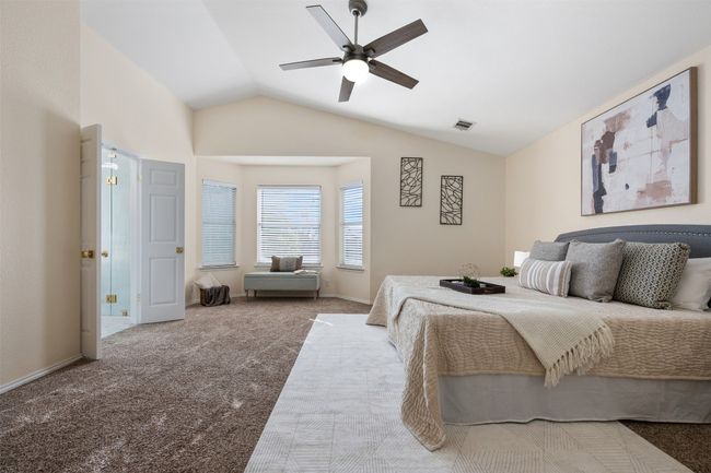 Bedroom featuring ceiling fan, visible vents, vaulted ceiling, carpet floors, and baseboards | Image 20
