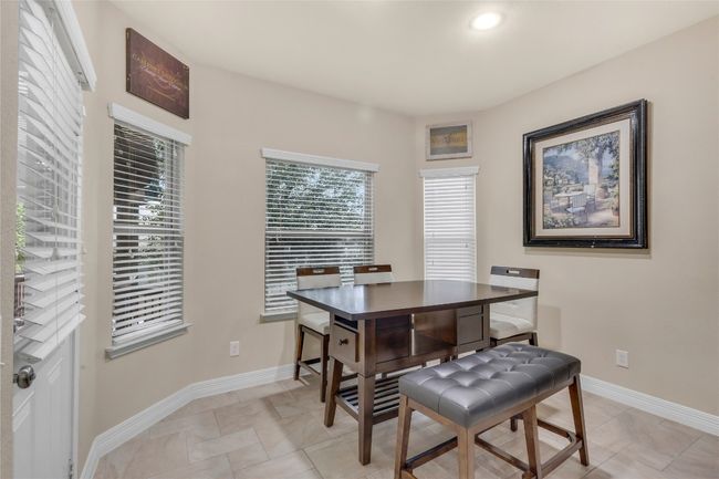 Dining space featuring wood finished floors, a chandelier, and arched walkways | Image 5
