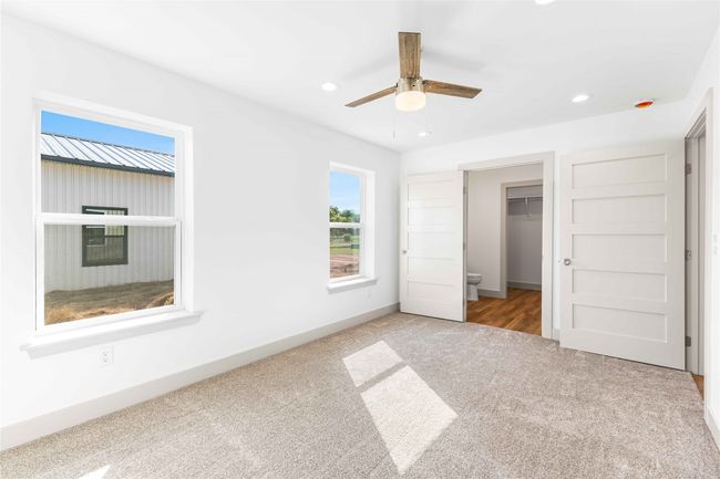 Unfurnished bedroom with carpet, recessed lighting, a walk in closet, ceiling fan, and a closet | Image 17