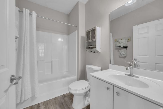Full bath featuring shower / bath combo, toilet, vanity, and wood finished floors | Image 20