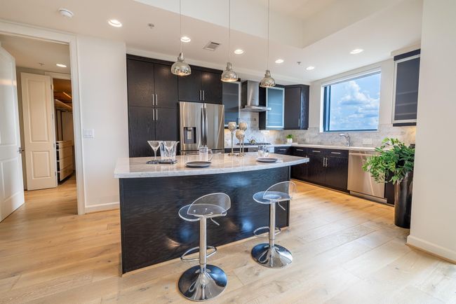 Luxurious kitchen featuring a stylish island with seating for casual dining and entertaining. | Image 20