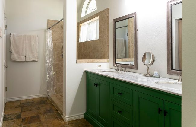Bathroom featuring double vanity, tiled shower, and stone finish floors | Image 15