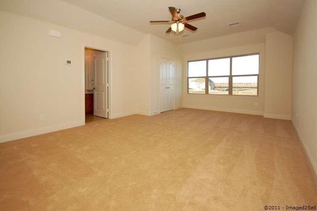 Spare room featuring a ceiling fan, light colored carpet, and baseboards | Image 19