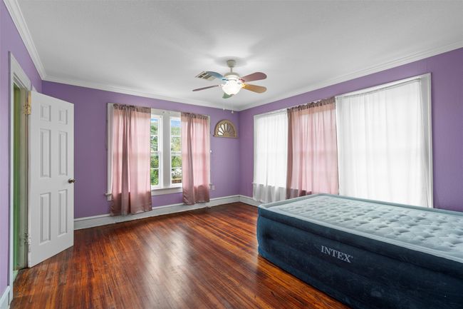 Unfurnished bedroom with crown molding, wood finished floors, and ceiling fan | Image 27
