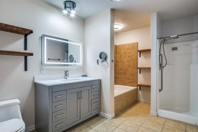 Bathroom featuring tile patterned flooring, vanity, a shower, and tiled tub | Image 18