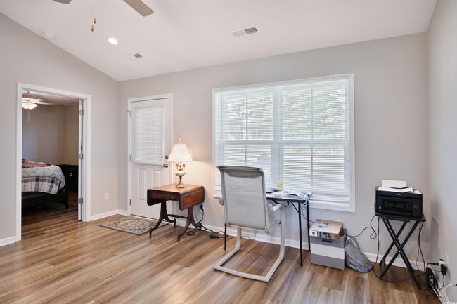 Sitting room featuring a ceiling fan, light wood-type flooring, lofted ceiling, and a desk | Image 15