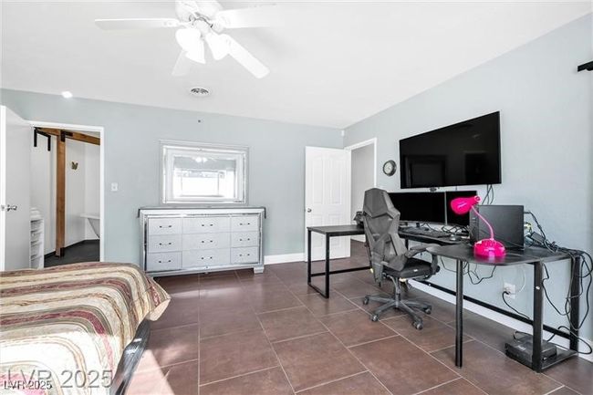 Bedroom with dark tile patterned flooring, a desk, and ceiling fan | Image 17