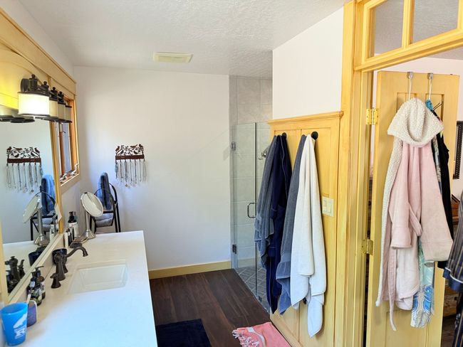 Bathroom with a stall shower, vanity, wood finished floors, wood accent walls | Image 39