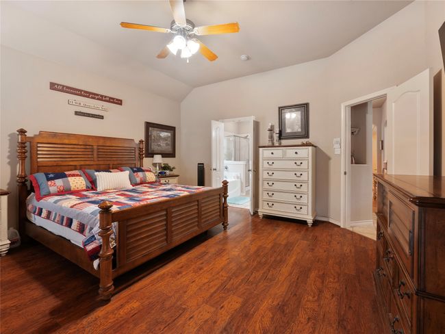 Bedroom with dark wood-style floors, lofted ceiling, ceiling fan, and ensuite bathroom | Image 17