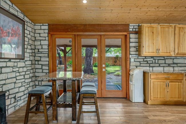 Dining room with wooden ceiling, light wood finished floors, and french doors | Image 21