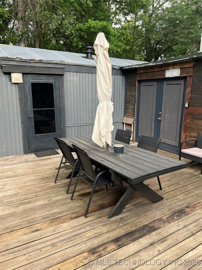 Deck with outdoor dining area and view of scattered trees | Image 31