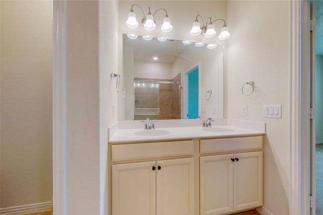 Bathroom featuring double vanity and a shower with door | Image 22