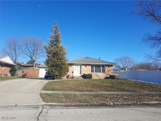 View of front of house featuring concrete driveway, fence, and a front lawn | Image 41