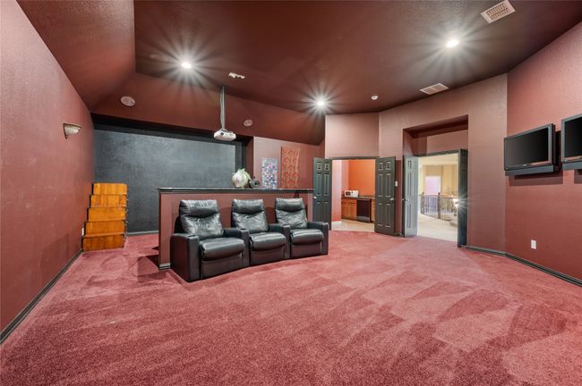 Home theater room with light colored carpet, recessed lighting, and a textured wall | Image 30