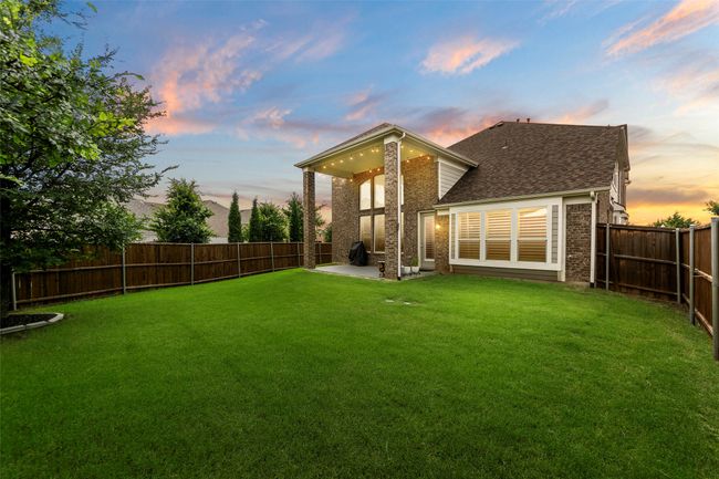 Back of house featuring brick siding, a patio, and roof with shingles | Image 39