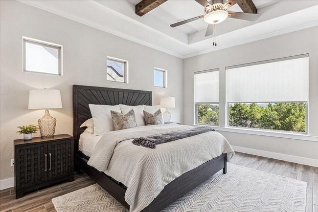 The serene primary suite offers a tranquil escape, with windows adorned with remote-controlled shades for ultimate privacy and sunlight control. When the water level is higher, you can acutally see Lake Travis from the primary bedroom windows. | Image 17