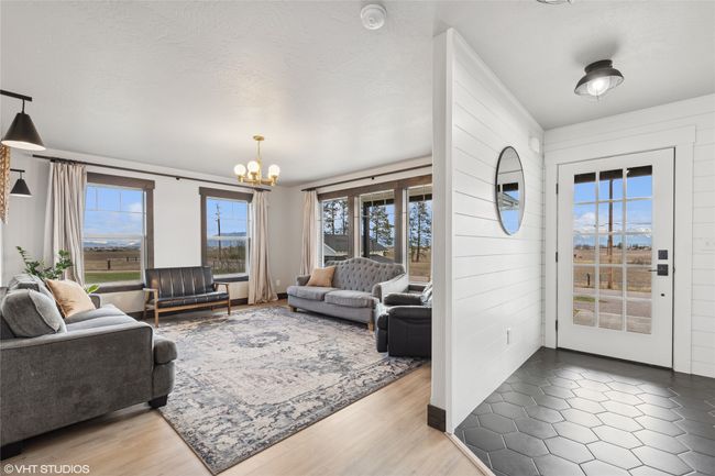 Living area with an inviting chandelier and wood finished floors | Image 5