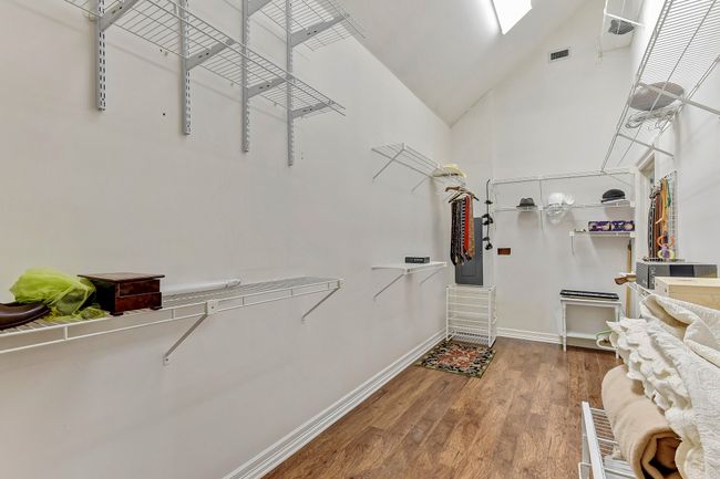 Spacious closet with high vaulted ceiling, wood finished floors, and visible vents | Image 19