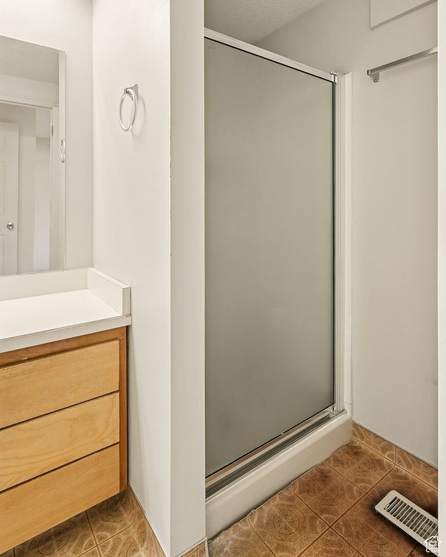 Bathroom with a shower stall, tile patterned flooring, and vanity | Image 22