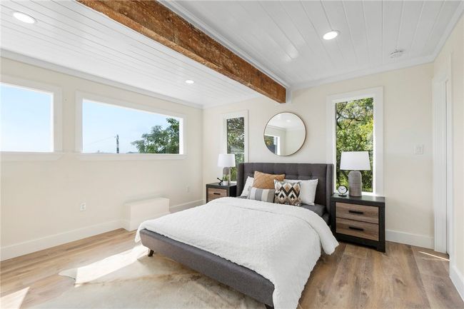 The loft-style secondary bedroom is located on the second floor with a beamed shiplap ceiling. | Image 21