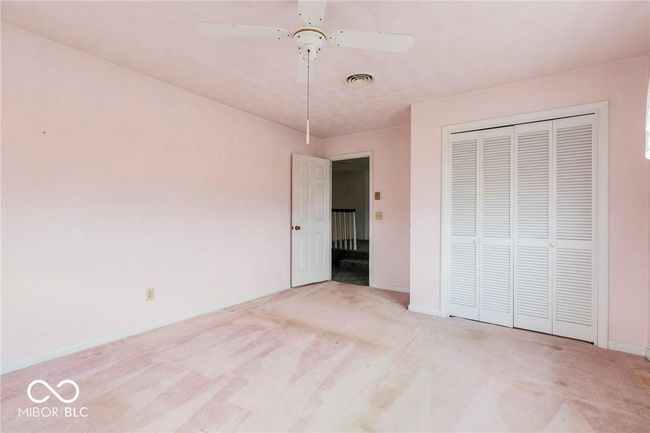 unfurnished bedroom with carpet flooring, a closet, and a ceiling fan | Image 27