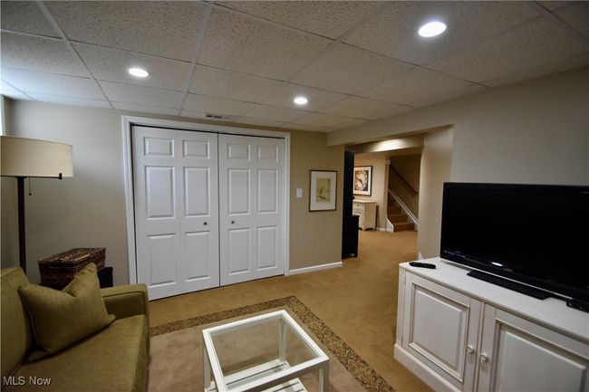 Rec room with light colored carpet, stairs, recessed lighting, and a paneled ceiling | Image 22