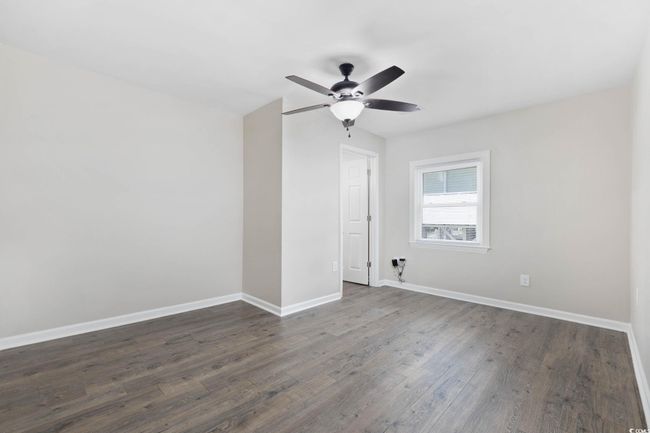 Empty room featuring dark wood-style floors, ceiling fan, and baseboards | Image 24