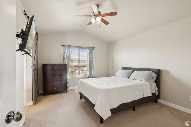 Primary Bedroom with light colored carpet, lofted ceiling, and a ceiling fan | Image 26