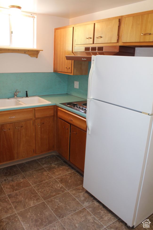 Kitchen with freestanding refrigerator, electric cooktop, and light countertops | Image 18