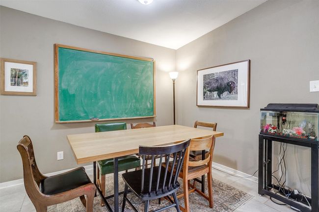 Dining space featuring light tile patterned flooring and baseboards | Image 12